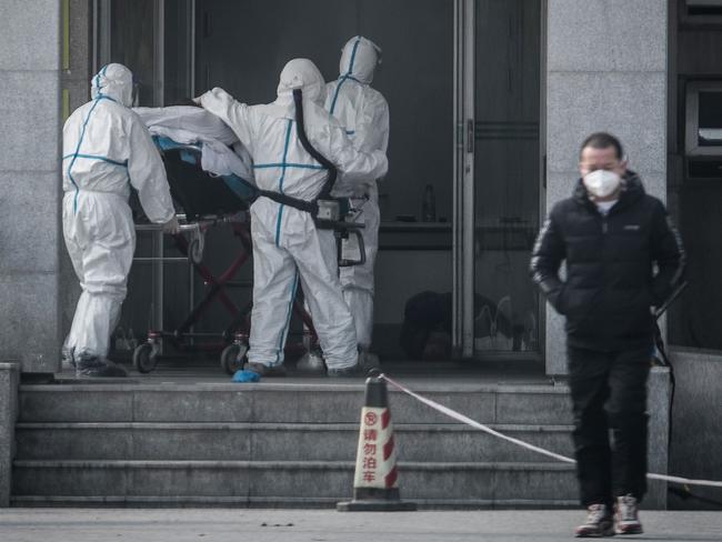 (FILES) This file photo taken on January 18, 2020 shows medical staff members carrying a patient into the Jinyintan hospital, where patients infected by a mysterious SARS-like virus are being treated, in Wuhan in China's central Hubei province. - A mysterious SARS-like virus has spread around China -- including to Beijing -- authorities said on January 20, 2020, fuelling fears of a major outbreak as millions begin travelling for the Lunar New Year in humanity's biggest migration. (Photo by STR / AFP) / China OUT