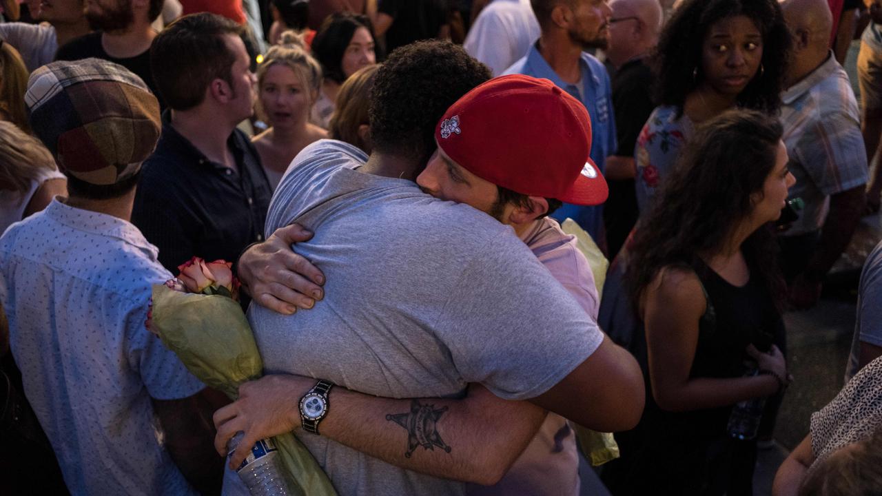 People comfort each other as they take part of a candle lit vigil in honour of those who lost their lives or were wounded in a shooting in Dayton, Ohio. Picture: Megan Jelinger / AFP