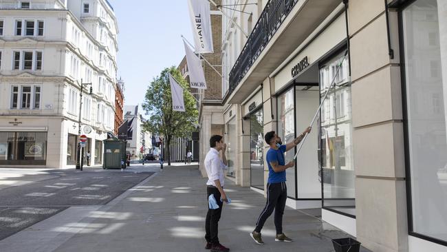 The windows of a Chanel store are cleaned in preparation for reopening. Picture: Getty Images