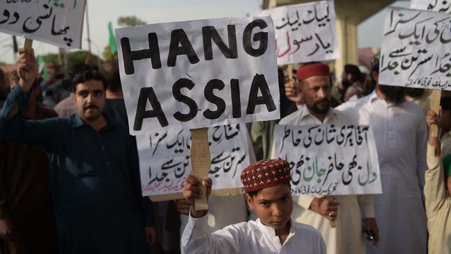 Supporters of Tehreek-e-Labaik Pakistan (TLP), a hardline religious political party hold placards as they march during a protest in Rawalpindi on October 12, 2018, demanding for hanging to a blasphemy convict Christian woman Asia Bibi, who is on death row. - Religious hardliners in Pakistan on October 10 threatened judges and announced protests as the country awaits a Supreme Court ruling on the fate of a Christian woman who faces becoming the first person to be executed for blasphemy. (Photo by AAMIR QURESHI / AFP)