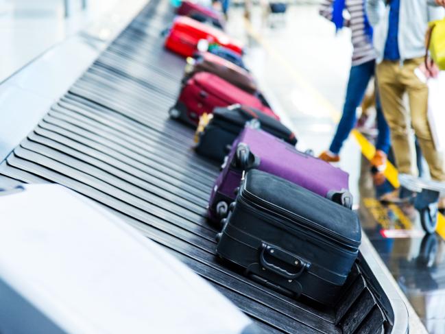 Luggages moving on airport conveyor belt.