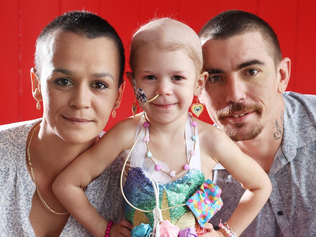 Stevee and Terry Kennedy with shaved heads with their daughter Emerara, 3, who is fighting neuroblastoma, East Brisbane. Picture: Liam Kidston