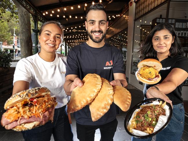 Migrant Coffee’s Stacey Earsman, A1 Bakery’s Daniel Raji and Burger Shurger’s Payal Bisht share the snacks as part of Melbourne Food and Wine Festival’s Snacktown. Picture: David Geraghty