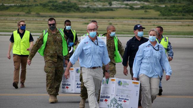 Australian officials carry boxes containing 8000 initial doses of the AstraZeneca vaccine at the Port Moresby international airport in Papua New Guinea on Tuesday. Picture: AFP