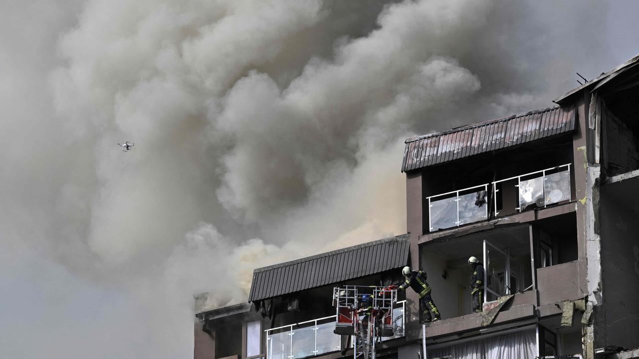 Firefighters at residential building hit by Russian missiles in Kyiv. NATO warns Putin could ‘lash out’ beyond Ukraine. Picture: AFP