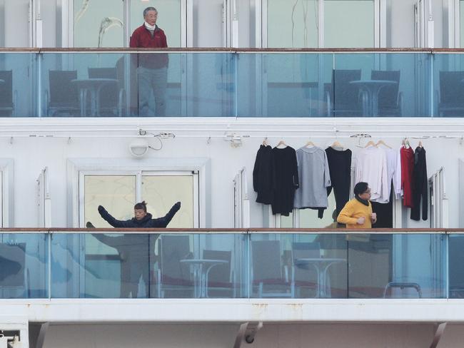 Passengers stand on balconies onboard the quarantined Diamond Princess cruise ship at Daikoku Pier Cruise Terminal in Yokohama on February 7, 2020. - Another 41 people on a cruise ship quarantined off Japan have the new coronavirus, the country's health minister said February 7, confirming more on board will now be tested for the illness. (Photo by - / JIJI PRESS / AFP) / Japan OUT