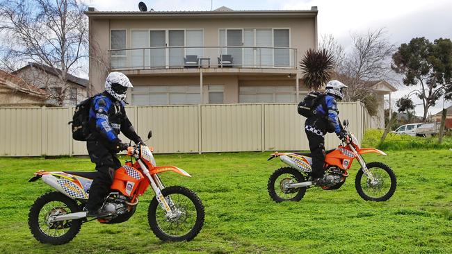 Police searching on motorbikes pass behind the Ristevski’s house. Picture: Hamish Blair