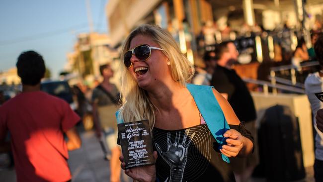 A woman hands out flyers in front of Cafe Del Mar on the Spanish holiday island of Ibiza. Picture: David Ramos/Getty Images