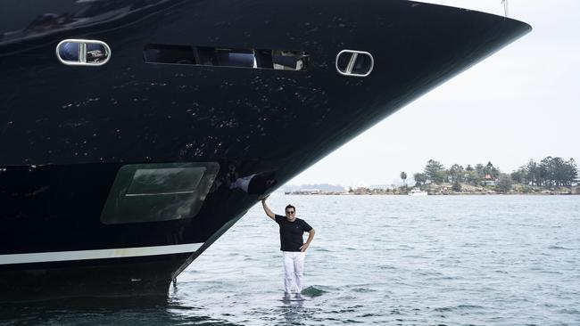 Ahoy Club founder Ian Malouf is dwarfed by the bow of his luxury superyacht Mischief on Sydney Harbour on Monday. Picture: John Feder