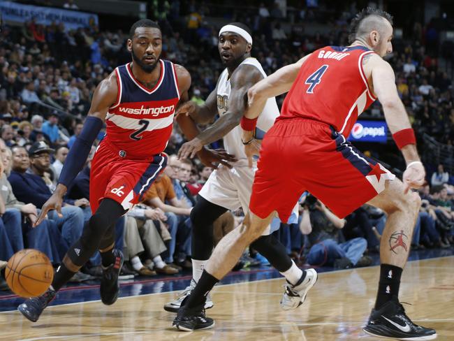 Washington’s John Wall, left, drives for a shot past Denver Nuggets guard Ty Lawson.