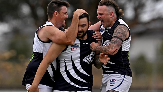 Matthew Eberle (centre) is mobbed after kicking a goal for Melton Centrals. Picture: Andy Brownbill