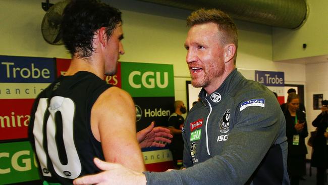 Buckley celebrates last Friday night’s win against the Bulldogs with captain Scott Pendlebury.