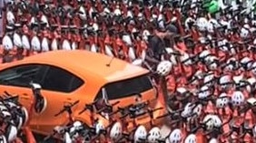 A man naviagtes hundreds of scooters parked around his car. Picture: TikTok