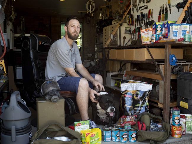 Shaughn Wright, with his dog Arrow, creates "bug out kits" with everything he and his family will need if they have to evacuate in a major crisis. Picture: Russell Shakespeare