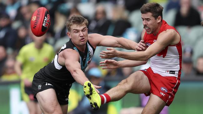 Sydney’s Jake Lloyd gets one of his 20 kicks away, under pressure from Ollie Wines, against Port Adelaide. Picture SARAH REED