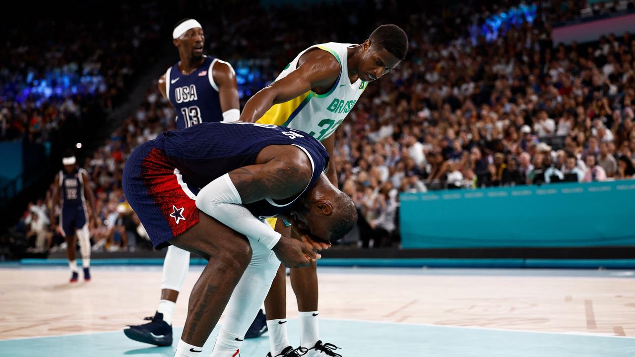 USA's #06 LeBron James reacts after being involuntarily hit in the face by Brazil's #32 Georginho De Paula (R) during a rebound, in the men's quarterfinal basketball match between Brazil and the USA during the Paris 2024 Olympic Games at the Bercy Arena in Paris on August 6, 2024. (Photo by Luis TATO / AFP)