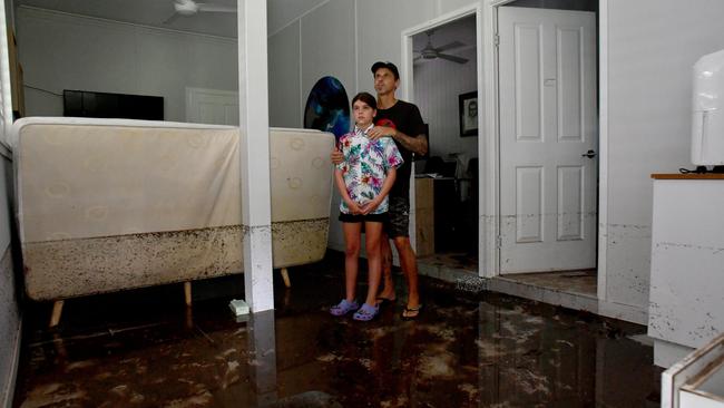 Tuesday February 4. Heavy rain causes flooding in North Queensland. Bluewater residents Anthony Waugh, with daughter Nyah, 9, at the ground floor of their Forrestry Road home inundated by a fast rising Bluewater Creek. Picture: Evan Morgan