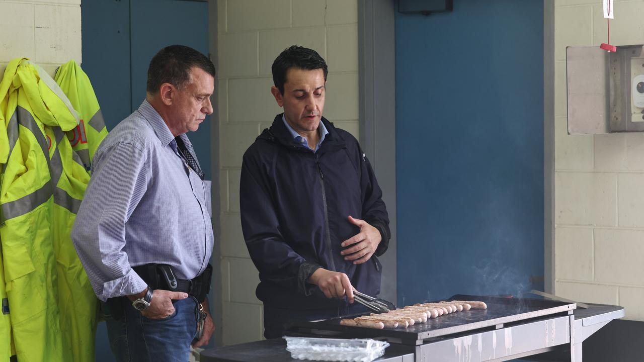 A monsoonal tropical low pressure system has brought devastating widespread flooding to North Queensland and parts of Far North Queensland, with ove 1000 millimetres of rain recorded in Cardwell. Queensland Premier David Crisafulli speaks with police officer Detective Sergeant Mike Anderson while he cooks a barbeque at the Cardwell Police Station. Picture: Brendan Radke