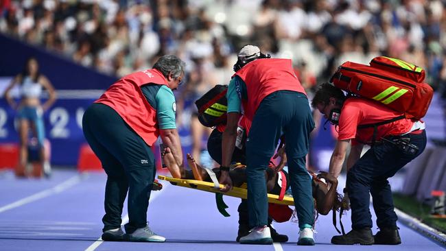 South Sudan's Lucia Moris is carried on a stretcher. Photo by Jewel SAMAD / AFP.