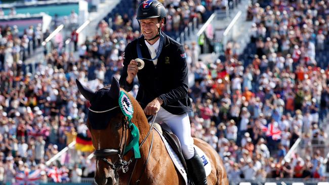 VERSAILLES, FRANCE - JULY 29: Silver medalist Christopher Burton with horse Shadow Man of Team Australia celebrate during a lap of honour after the medal ceremony for the Eventing Jumping Individual Final on day three of the Olympic Games Paris 2024 at Chateau de Versailles on July 29, 2024 in Versailles, France. (Photo by Kevin C. Cox/Getty Images)