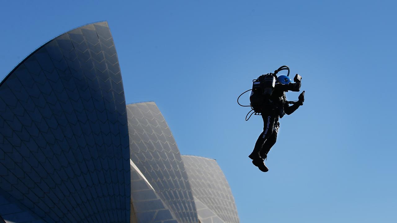 Australian David Mayman demonstrating the world’s first real jetpack high above the sails of the Sydney Opera House on Sunday. Picture: Jane Dempster