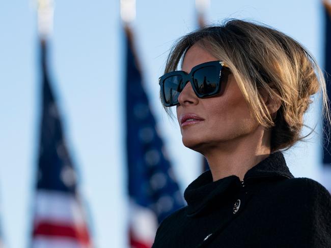 (FILES) In this file photo outgoing First Lady Melania Trump listens as her husband Outgoing US President Donald Trump addresses guests at Joint Base Andrews in Maryland on January 20, 2021. - The backdrop of flowers, teapot and US flag said it all: Jill Biden will be no Melania Trump as America's new first lady. Where Donald Trump's ex-model wife cut a flashy but often distant figure, Jill Biden's appearance on a Zoom "virtual tea" party February 3 with military spouses affirmed her image as a down-to-earth, traditional FLOTUS. (Photo by ALEX EDELMAN / AFP)