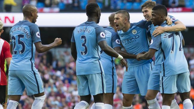 Manchester City players celebrate after an own goal.