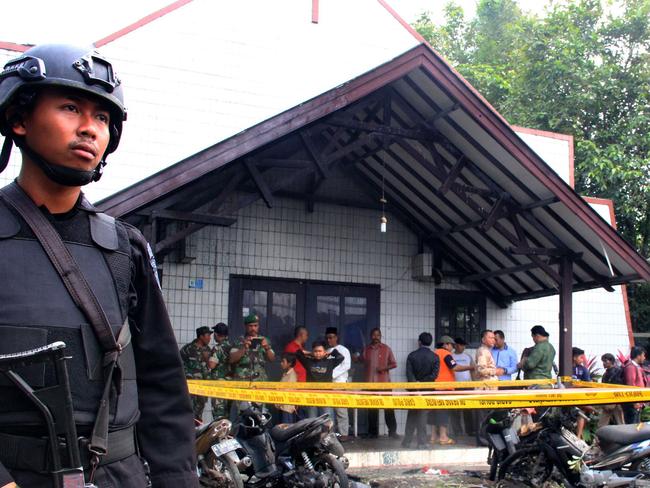 An Indonesian policeman stands guard outside the Oikume Church after a man allegedly threw Molotov cocktails towards it in Samarinda, East Kalimantan, on November 13, 2016. Several children were injured after a man allegedly threw Molotov cocktails at a church during a Sunday service on November 13 in Indonesia, police said. / AFP PHOTO / STRINGER