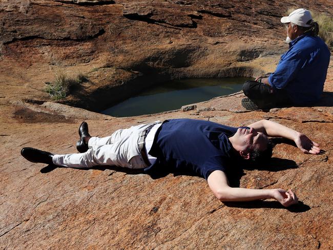 Steven Marshall soaks up the sun with APY Cultural Liasion and Aboriginal elder Lee Brady near a series of rock pools. Picture: Dylan Coker