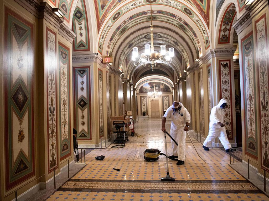 Workers clean damage near an overrun Capitol Police checkpoint a day after a pro-Trump mob broke into the US Capitol. Picture: Brendan Smialowski / AFP