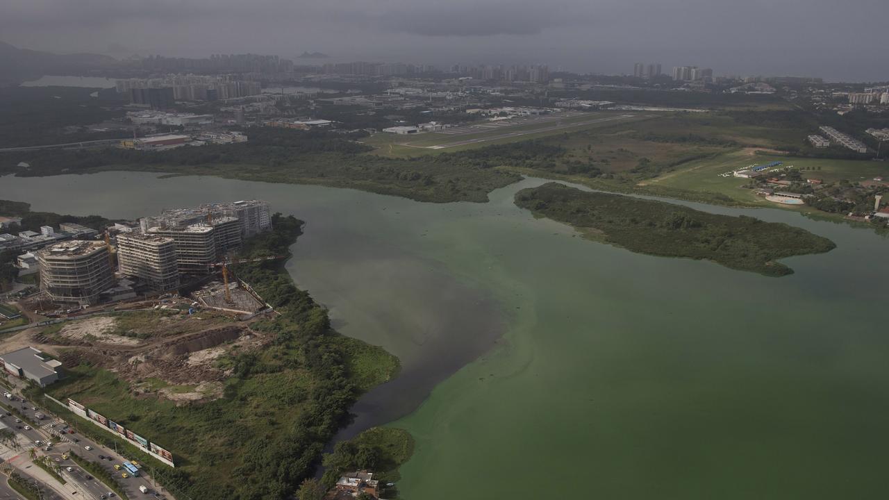 This July 27, 2015 aerial photo shows fluorescent green waters in the Marapendi Lagoon, in Rio de Janeiro, Brazil. The lagoons that hug the Olympic Park and which the government’s own data shows are among the most polluted waters in Rio were to be dredged, but the project got hung up in bureaucratic hurdles and has yet to start. (AP Photo/Leo Correa)