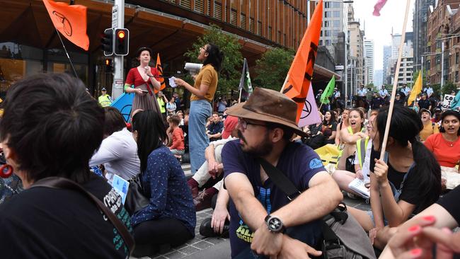 Extinction Rebellion protesters sit down outside AGL’s headquarters on George St. Picture: Flavio Brancaleone