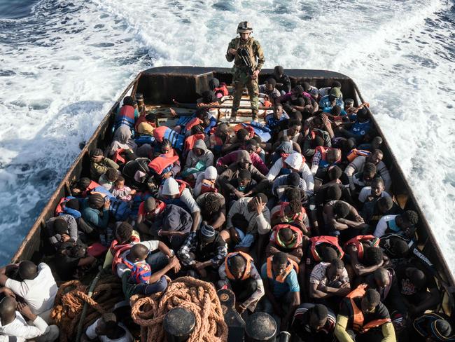 -- AFP PICTURES OF THE YEAR 2017 --  A Libyan coast guardsman stands on a boat during the rescue of 147 illegal immigrants attempting to reach Europe off the coastal town of Zawiyah, 45 kilometres west of the capital Tripoli, on June 27, 2017. More than 8,000 migrants have been rescued in waters off Libya during the past 48 hours in difficult weather conditions, Italy's coastguard said on June 27, 2017. / AFP PHOTO / Taha JAWASHI