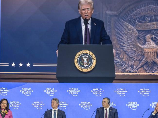 US president Donald Trump appears on a giant screen as he adresses Donald Trump global elites via video conference at the World Economic Forum in Davos on January 23, 2025. (Photo by Fabrice COFFRINI / AFP)