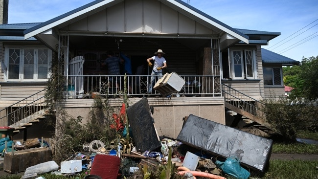 A resident throwing out damaged belongings. Picture: Dan Peled/Getty Images