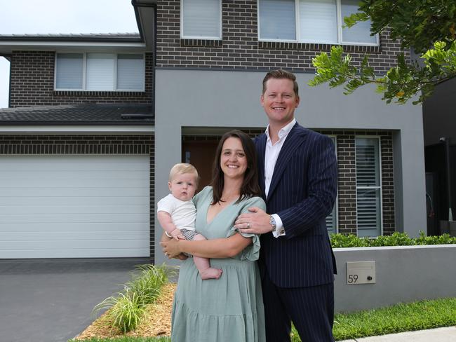 10/02/2023. Taylor and Ashleigh Bredlin, aged 31 and 29, with baby Harvey, 8 months old. They recently sold their North Kellyville home at auction above reserve for $1.809m. They wanted to sell now ahead of any market falls so they know exactly how much they have to spend when they start looking to buy later this year. Photographed in front of their home in North Kellyville, in Sydney's Western suburbs. Britta Campion / The Australian