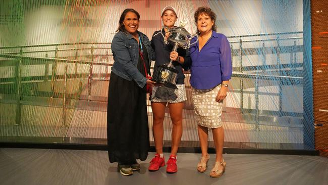 Ash Barty with the Australian Open trophy is congratulated by Evonne Goolagong Cawley and Cathy Freeman after winning the women's singles final at Melbourne Park Picture: Scott Barbour/Tennis Australia