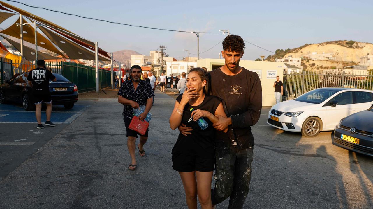 People react at a site where a reported strike from Lebanon fell in Golan Heights. Picture: Jalaa Marey/AFP