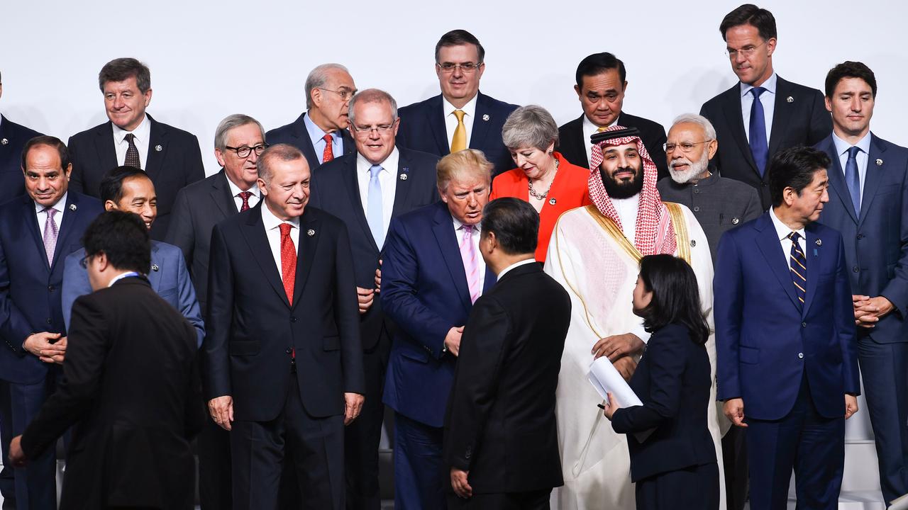 US President Donald Trump shakes hands with China's President Xi Jinping as the world leaders being urged to ‘pull humanity back from the brink’ take a family photo at the 2019 G20 Summit. Picture: Brendan Smialowski/AFP