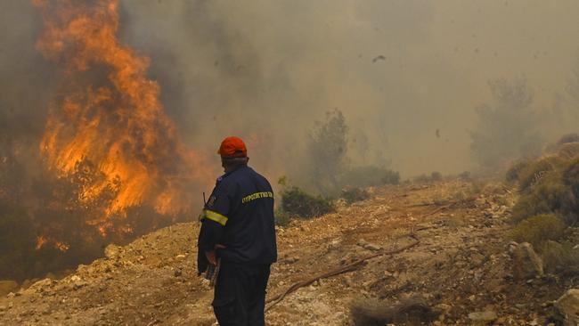 A firefighter tries to extinguish a fire burning near the village Vlyhada near Athens. Picture: Getty Images.