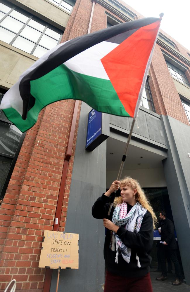 A student waves a Palestine flag outside the misconduct hearings at University of Melbourne. Picture: Andrew Henshaw