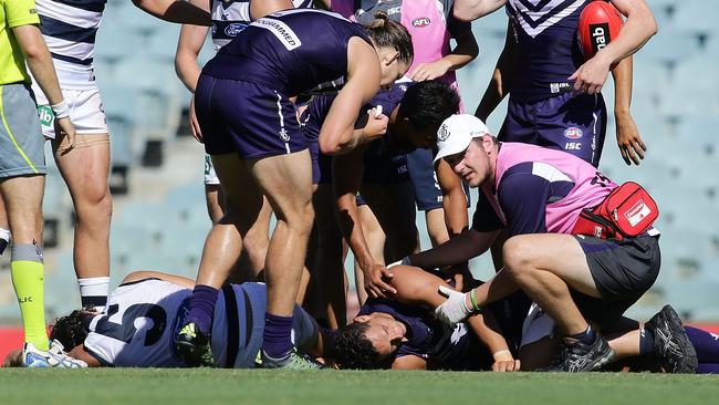 PERTH, AUSTRALIA - MARCH 12: Michael Johnson of the Dockers is assesed by a medic after being spear tackled by Nakia Cockatoo of the Cats during the 2016 NAB Challenge match between the Fremantle Dockers and the Geelong Cats at Domain Stadium, Perth on March 12, 2016. (Photo by Will Russell/AFL Media/Getty Images)