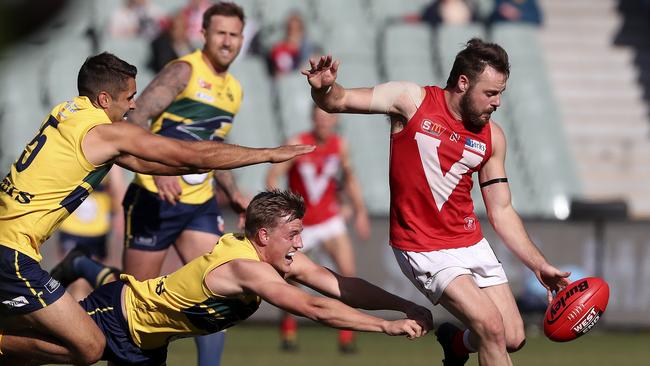 North Adelaide captain Max Thring gets his kick away from Jared Petrenko and Nick Hayes during the preliminary final. Picture SARAH REED