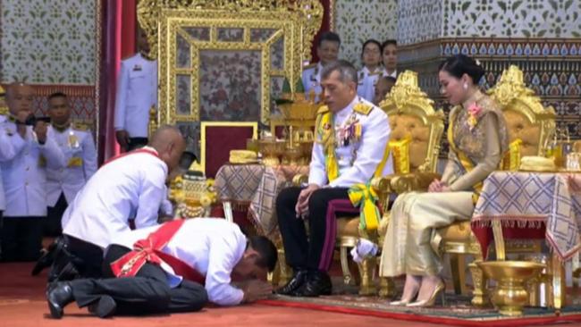 Thailand's Prime Minister Prayut Chan-O-cha, left, pays his respects to King Maha Vajiralongkorn, who is flanked by Queen Suthida. Picture: AFP