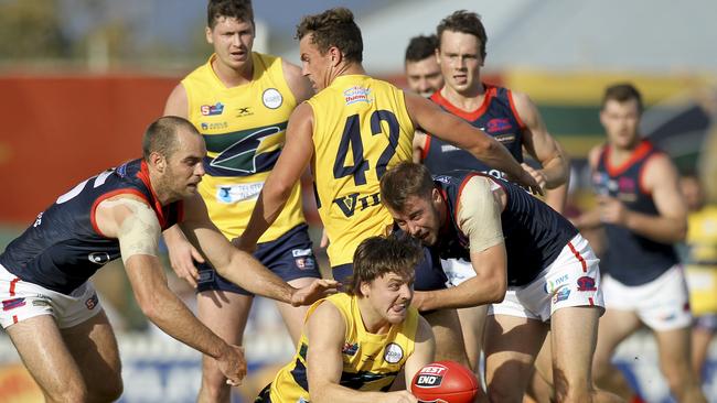 Eagles’ James Rowe handballs out of trouble under pressure from Norwood's Mitchell Wilkins (front) and Jace Bode (left). Picture: AAP/Dean Martin