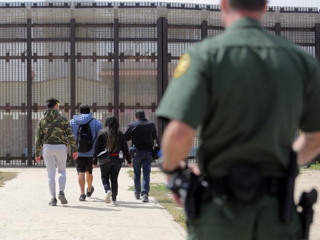 A Border Patrol officer watches as visitors walk up to the border wall with Mexico in San Diego, California. Picture: Bill Wechter/Getty Images/AFP