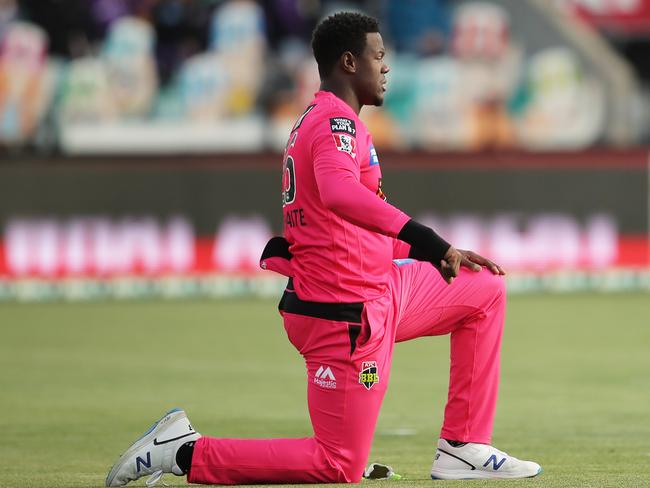 HOBART, AUSTRALIA - DECEMBER 10: Carlos Brathwaite of the Sixers takes a knee during the Big Bash League match between the Hobart Hurricanes and Sydney Sixers at Blundstone Arena, on December 10, 2020, in Hobart, Australia. (Photo by Matt King/Getty Images)