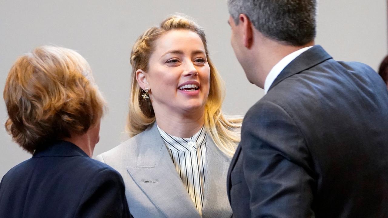 Actor Amber Heard talks with her legal team including Elaine Bredehoft, left, and Benjamin Rottenborn. (Photo by Steve Helber / POOL / AFP)