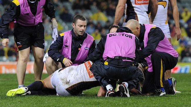 Eagle Dean Cox in the hands of the trainers after knock to the head. Picture: Daniel Wilkins