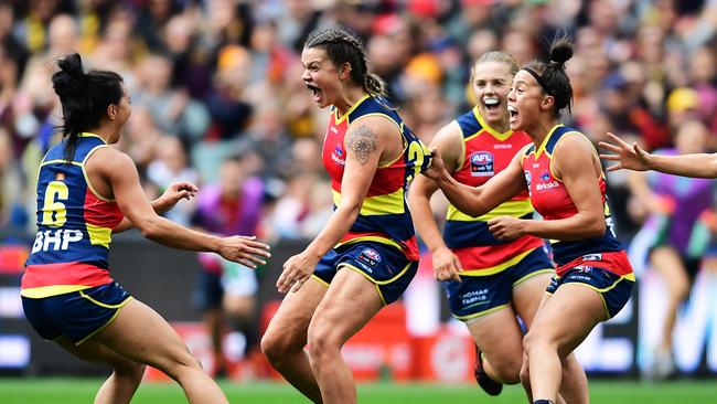 Anne Hatchard (middle) celebrates a Crows goal in the grand final with Hannah Martin (left) and Justine Mules. All three have signed new deals with the club. Picture: MARK BRAKE (Getty Images).